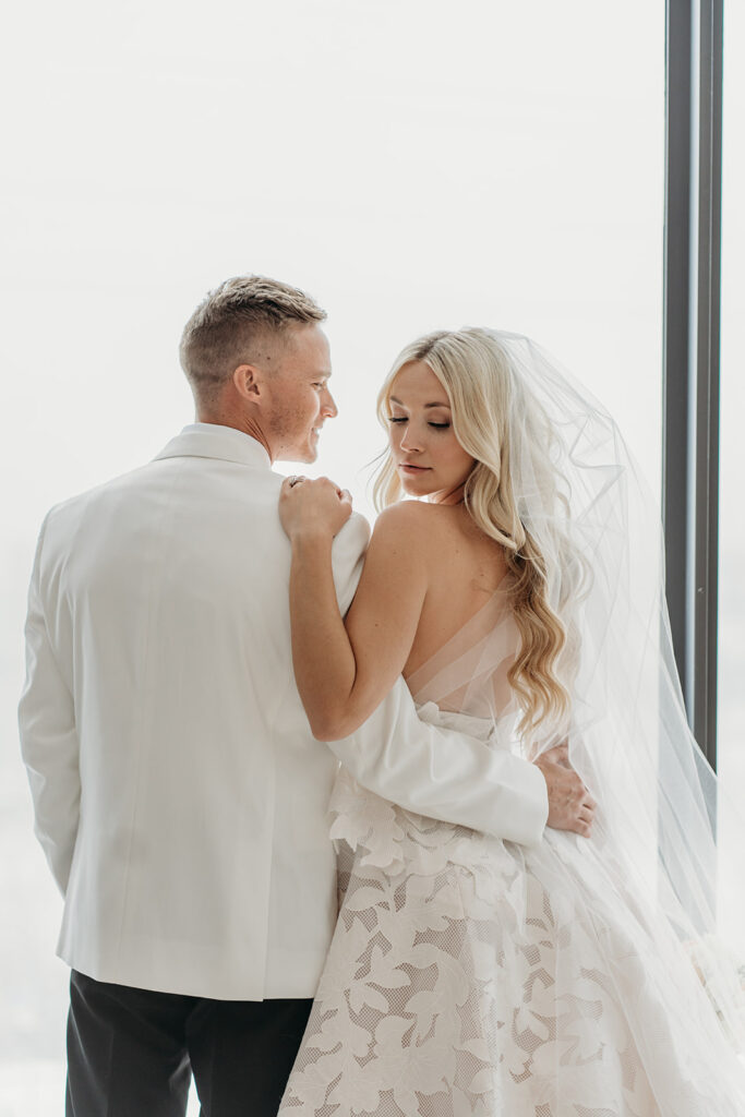 Bride and groom in a modern wedding portrait with soft natural light, neutral tones, and minimal styling